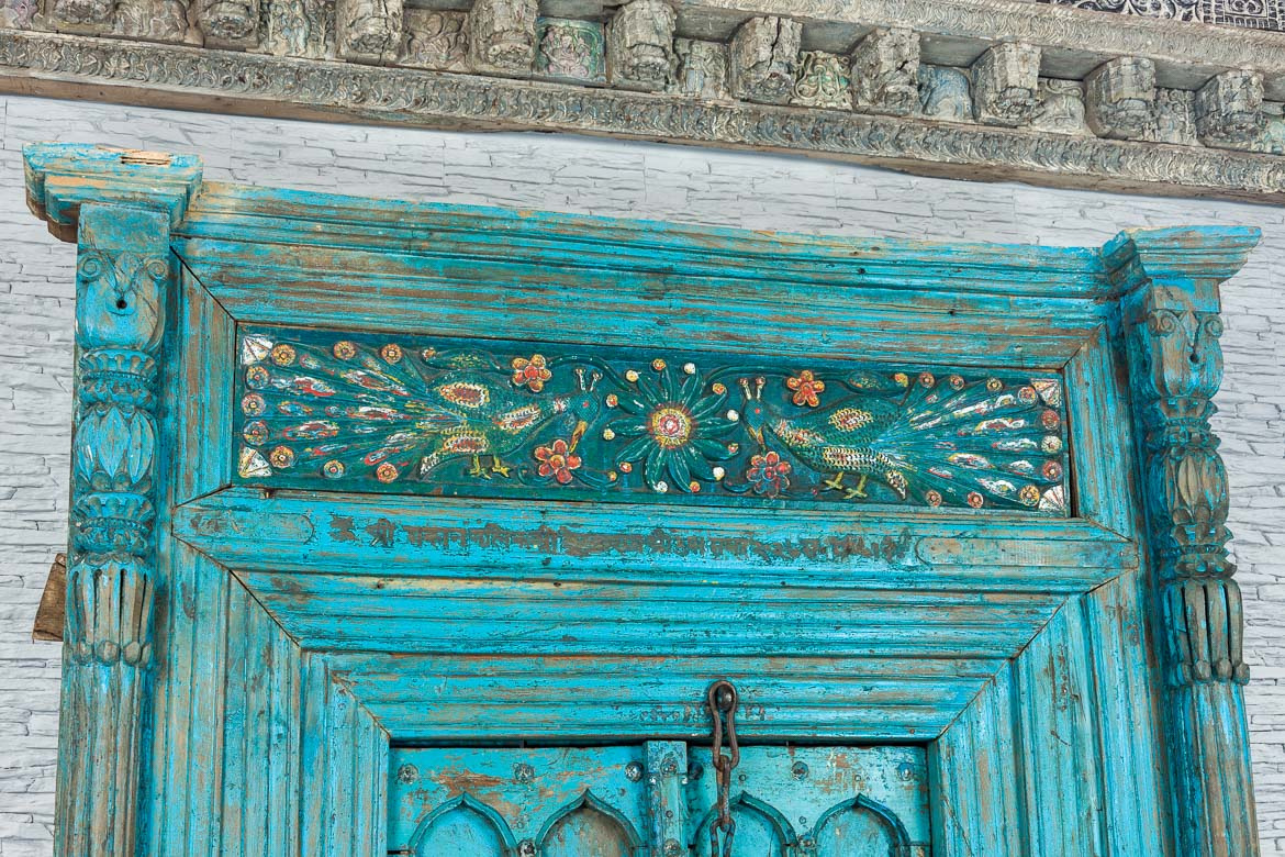 Duże stare niebieskie drzwi indyjskie z pawiami